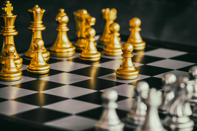 Close-up of chess pieces on board against black background