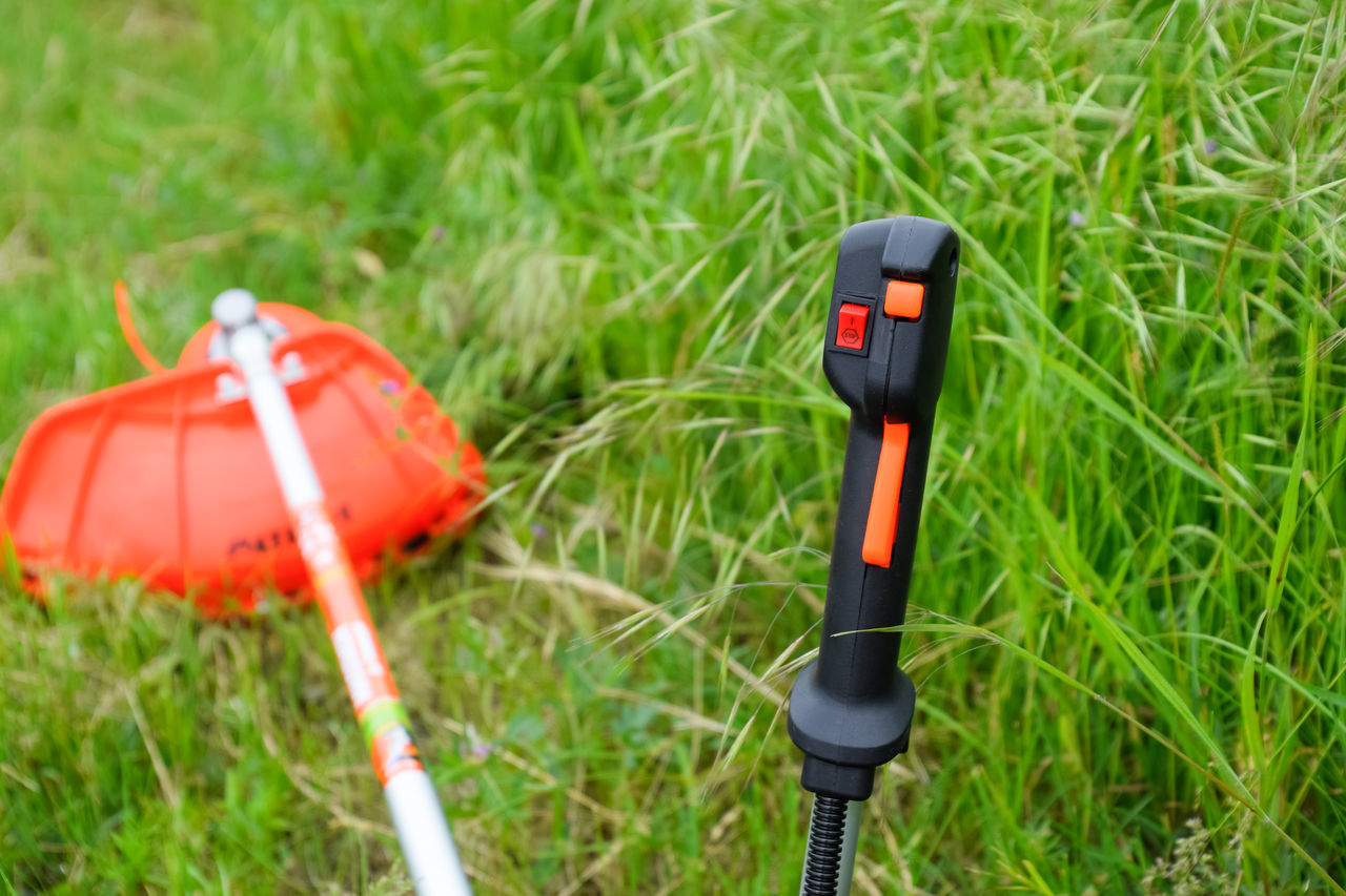 HIGH ANGLE VIEW OF UMBRELLA ON GRASSY FIELD