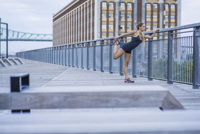 Woman standing on bridge in city