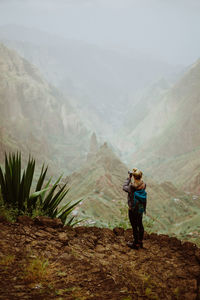 High angle view of woman standing on cliff