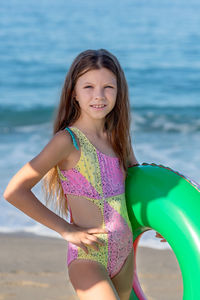 Portrait of a happy teenage girl with an inflatable rubber ring having fun on the beach. 