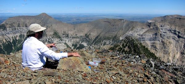 Man sitting on rock looking at mountains