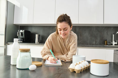 Portrait of young woman preparing food at home