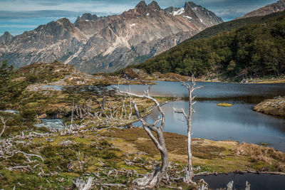 Scenic view of lake by mountains against sky