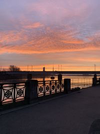 Bridge over sea against sky during sunset