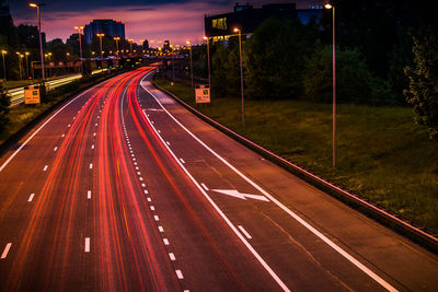 Light trails on road against sky at night