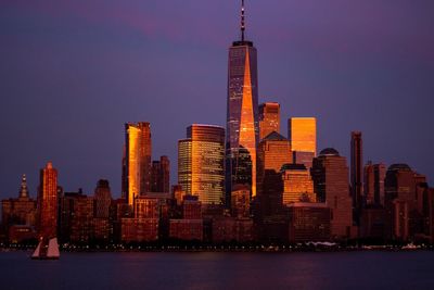 Illuminated buildings in city against sky