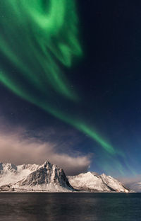 Scenic view of snowcapped mountains against sky at night