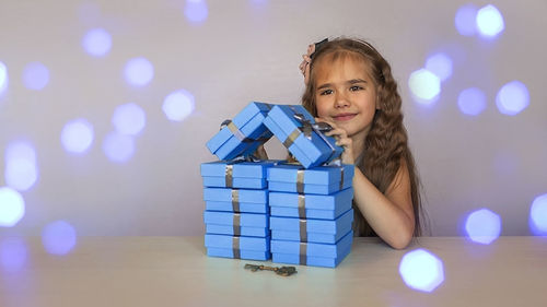 Portrait of woman holding illuminated christmas tree