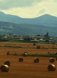 Hay bales on field against sky