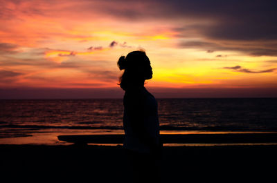A sillouette of a girl. behind is the beautiful sunset in sugar beach, sipalay, philippines. 
