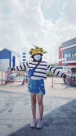 Rear view of woman standing against sky in city