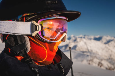 Profile of a female skier in ski goggles in the mountains. a woman in a sports ski jacket and