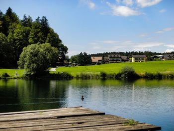 Scenic view of lake by building against sky