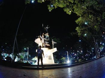 Statue in city at night