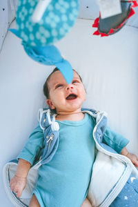 High angle view of baby lying on crib