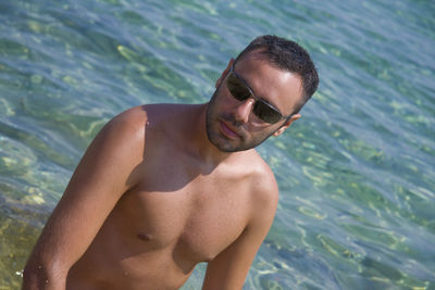 Shirtless man standing at beach