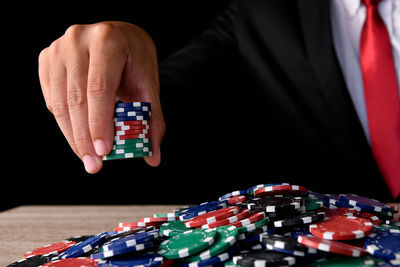 Midsection of businessman gambling in casino