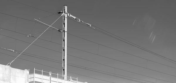 Low angle view of cables against building against clear sky