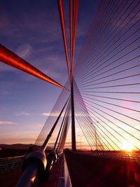 Low angle view of suspension bridge against sky during sunset