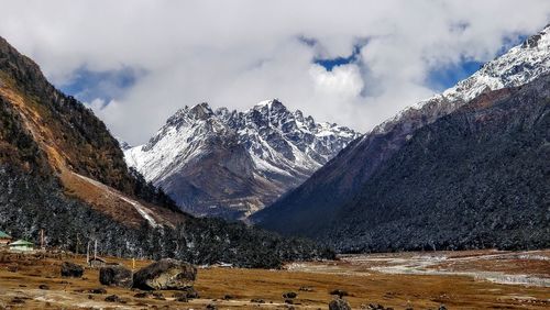 Scenic view of valley with snowcapped mountain in the background 