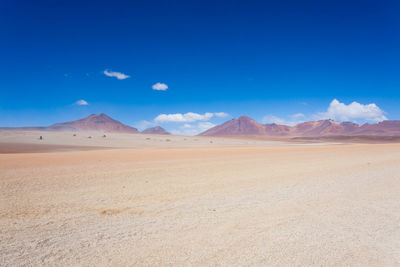 Scenic view of desert against blue sky