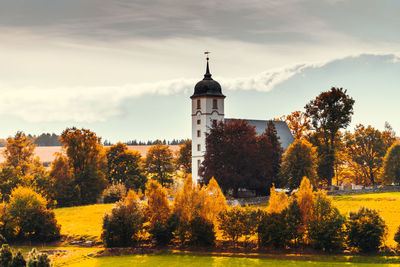 Trees and buildings against sky during autumn