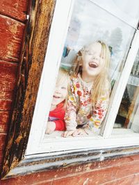 Portrait of little girs looking through window