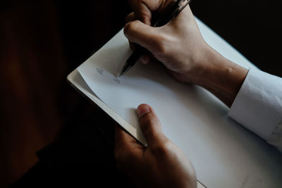 High angle view of man reading book on table