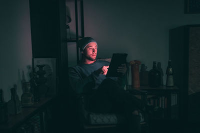 Man using digital tablet in dark