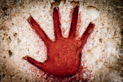 Close-up of human hand on old wall