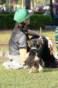 Rear view of woman with dog sitting outdoors