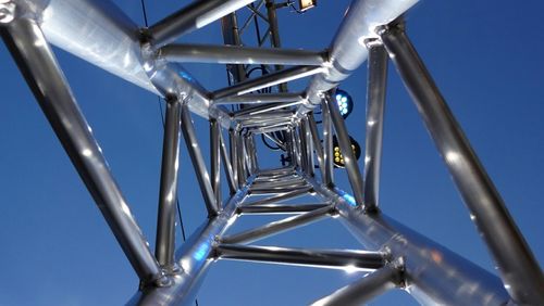 Low angle view of metallic structure against blue sky