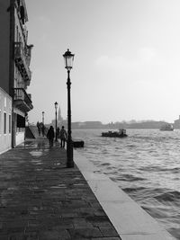 People at sea shore against sky