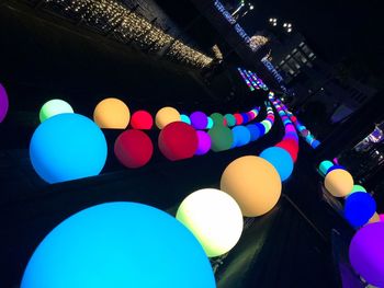 Low angle view of illuminated balloons in building at night