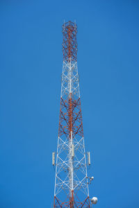 Low angle view of communications tower against clear blue sky