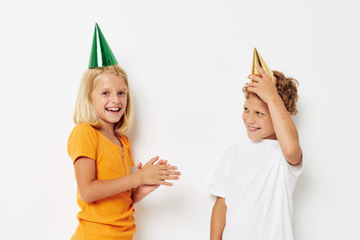 Smiling sibling wearing party hat