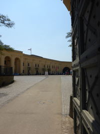 Street amidst buildings against clear sky