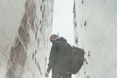 Man standing by wall against building