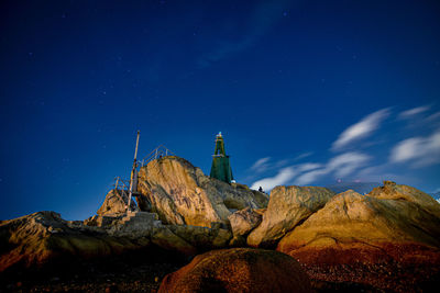 Low angle view of rock formation against sky at night