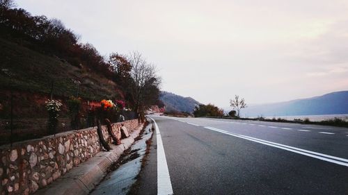 Road amidst trees against sky