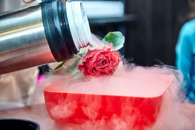 Water being poured on rose in container