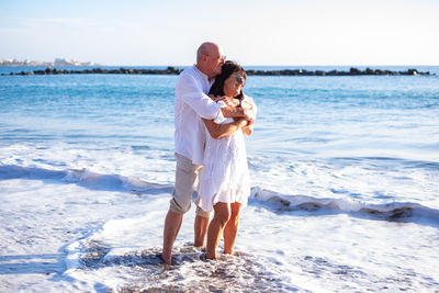 Full length of young woman in sea against sky