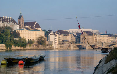 Scenic view of river by buildings against clear sky