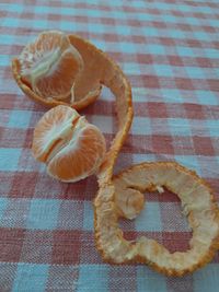 Orange slices and peel on a table with a checkered tablecloth 