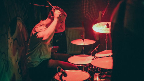 Midsection of man playing music in the dark