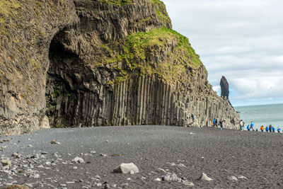 Tourists visiting the reynisfjara beach and basalt columns on the atlantic coast of iceland in vik