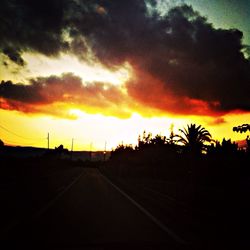 View of road against cloudy sky at sunset