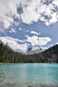 Scenic view of lake by mountains against sky