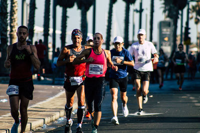 People running on street in city